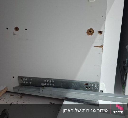 מסילה מתכתית מותקנת בארון עץ לבן